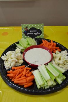 carrots, celery and cauliflower arranged in a bowl with dip