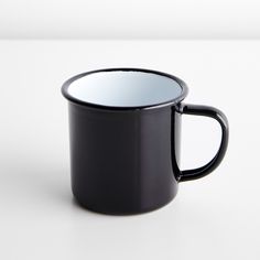 a black and white coffee cup sitting on top of a table