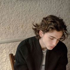 a young man sitting down looking at his cell phone