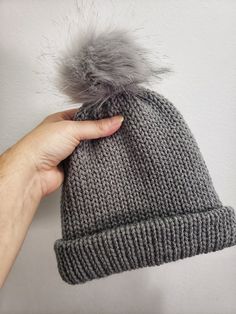 This winter hat is perfect for a young child to wear outside in the cold.   Machine knitted by me. Pom pom is secured around a button on top of hat for easy removal for washing. Measures 7 inches tall when brim is folded up.  And approximately 18 inches wide. Perfect for 2 to 4 year old.  Maybe even 5 year old. Warm Gray Bonnet One Size Fits Most, Adjustable Warm Gray Beanie, Warm Gray Bonnet Cap, Adjustable Knitted Gray Hat, Gray Winter Crochet Hat With Soft Knit, Winter Gray Crochet Hat With Soft Knit, Gray Soft Knit Crochet Hat For Winter, Gray Cold Weather Hat, One Size Fits Most, Gray Hats For Cold Weather