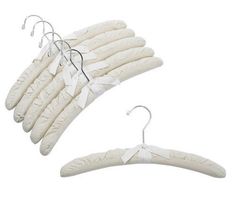 four white hangers with clips on them