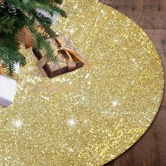 a christmas tree with presents on it and a gold glitter table mat in the middle