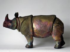 a bronze statue of a rhinoceros on a white background