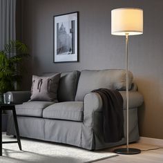 a living room scene with focus on the couch and floor lamp in the foreground