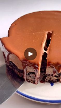 a chocolate cake on a plate with a knife in the middle and one slice missing from it