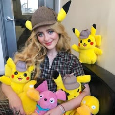 a woman sitting on a couch holding several stuffed animals