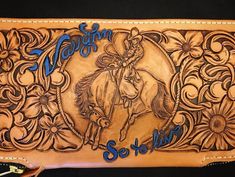 an image of a leather case with a horse and flowers on the inside, in blue lettering