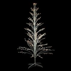 a white christmas tree with lights on it's branches in front of a black background