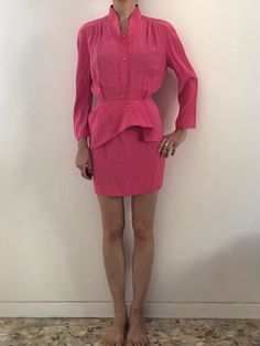 Wow! Amazing Thierry Mugler hot pink suit set.  Very cute Barbie energy! The suit is made amazingly, like all Mugler pieces. Super stitching and construction - couture quality.  The fabric is a heavy rayon and acetate with a shiny satin interior. It has a great heavy weight with a wonderful drape.  The jacket has a 1940's style.  Kimono sleeves with gathers at the shoulders.  The neckline is deep and open with a band collar.  Pink plastic snaps up the front.  Asymmetrical reinforced peplum! Also one cool Mugler pocket on the peplum.  Mini skirt has a high waist and a fitted shape.  Pink plastic snaps up the back.  Waist band with V detail.  Both pieces are unlined. The fabric is satin on the inside.  Label Thierry Mugler Paris, Skirt has the size 38, 67% acetate, 33% viscose. Dry Clean onl Elegant Pink Skirt Suit For Party, Elegant Pink Party Skirt Suit, Spring Pink Skirt Suit For Party, Chic Fitted Pink Sets, Chic Pink Party Skirt Suit, Chic Pink Skirt Suit For Party, Chic Pink Skirt Suit For Formal Events, Chic Pink Skirt Suit For Formal Occasions, Chic Fitted Pink Skirt Suit