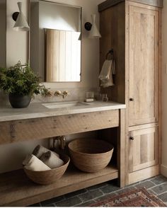 a bathroom vanity with two wooden bowls on the counter and an instagram button above it