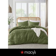 an image of a bed with green comforter and pillows