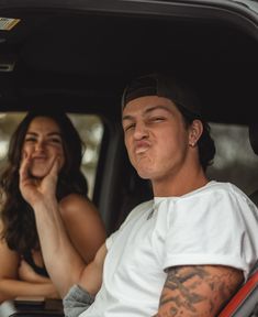 a man and woman sitting in the back of a car