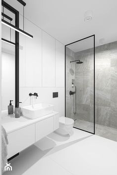 a white bathroom with two sinks and a walk in shower next to a large mirror