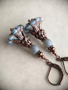 Czech glass flower earrings in an ornate, antique style inspired by the Victorian era. I loved the intricacy of these denim blue Czech glass flower beads, so I decorated them with little copper leaves and other copper decorations, and added some round blue beads with an interesting texture, then added some final antiqued copper accents, and tiny Czech glass beads in an antiqued copper color. These earrings measure almost 2 inches, or almost 5 cm, including the leverback earwires. They are also available with French earwires if you prefer (see last photo); these have a similar length. All of the beads are Czech glass and the metal is antiqued copper plated. For more beautiful flower earrings, make sure to check out the rest of my shop! https://www.etsy.com/shop/ForbiddenGlade?section_id=669 Blue Adjustable Czech Glass Beaded Earrings, Blue Faceted Czech Glass Jewelry, Blue Czech Glass Flower Earrings, Blue Czech Glass Drop Earrings, Bohemian One-of-a-kind Czech Glass Jewelry, Copper Decor, Copper Accents, Lampwork Jewelry, Copper Color