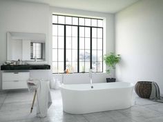 a large white bath tub sitting next to a window