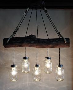 five mason jar lights hanging from a wooden beam