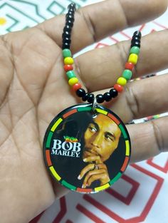 Introducing...the ultimate accessory for fans of legendary reggae roots singer, Bob Marley - beaded necklaces in classic red, yellow and green Rasta colors! These Jamaican-inspired chains will add a touch of island vibes to any outfit. Get your rasta bead neck chain today and show off your love for Bob Marley in style! Elevate your style with these Bob Marley Beaded Necklaces, Featuring a bold Red, Yellow and Green Rasta chain. The pendant, measuring 1.5 inches, is made of vibrant acrylic Pendan Hippie Red Round Bead Jewelry, Retro Multicolor Jewelry For Festivals, Multicolor Retro Festival Jewelry, Caribbean Flags, Rasta Lion, Marble Necklace, Rasta Colors, Lion Necklace, Island Vibes