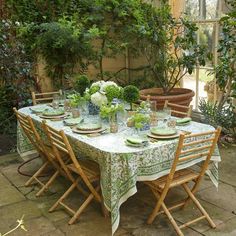 the table is set with green plates and flowers