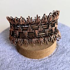 You'll love this wide, chunky, one-of-a-kind artisanal copper wire cuff. Handcrafted with copper wire, this cuff features intricate details and an adjustable fit. Oxidized and hand polished, this cuff has been coated to preserve the finish. I love the fringe effect on the wrapping on the top and bottom. One size fits most - adjust by gently pulling and squeezing the sides Copper wire Handmade in Lincoln, Nebraska Handmade Bohemian Copper Wire Cuff Bracelet, Bohemian Copper Wire Cuff Bangle Bracelet, Handmade Copper Wire Cuff Bangle, Handmade Copper Wire Cuff Bracelet Bangle, Adjustable Wire Wrapped Bronze Cuff Bracelet, Adjustable Brown Copper Bangle, Adjustable Hand Wrapped Bronze Cuff Bracelet, Bohemian Copper Wire Wrapped Cuff Bracelet, Handmade Adjustable Copper Cuff Bracelet