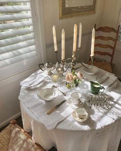 the table is set with dishes and candles