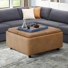 a living room with a sectional couch and coffee table in front of the sofa is an ottoman