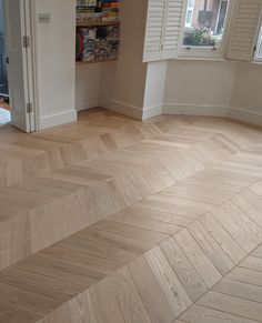 an empty room with wooden floors and white shutters