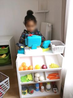 a small child is playing with toys on a shelf