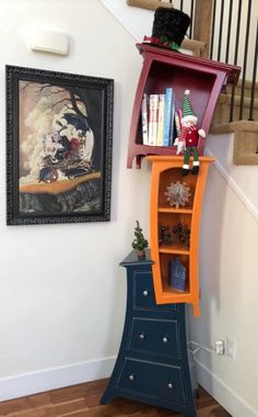 an orange and blue book shelf next to a stair case