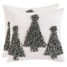 three black and white christmas trees on a white pillow