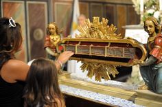 a woman looking at a statue of jesus holding the body of christ in front of her