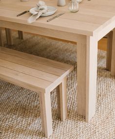 a wooden table with two benches next to each other on a carpeted room floor