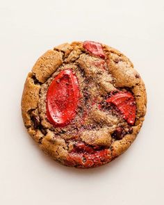 a chocolate chip cookie with strawberries on the top and crumbs all over it