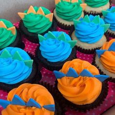 cupcakes with blue and orange frosting in a box