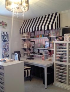 a desk with lots of drawers underneath a black and white striped awning