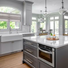 a large kitchen with an island in the middle and lots of windows on both sides