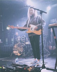 a person standing on stage with a guitar