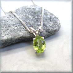 A gorgeous natural peridot oval has been handset into a sterling silver setting. The setting allows light to penetrate the stone and allows the color to really sparkle. Perfect pendant for anyone born in August as peridot is their birthstone. Also makes a wonderful layering necklace. The stone is 8x6mm in size. The setting and curb chain are both 925 sterling silver. Items are shown larger in pictures to show detail - please note the dimensions. Jewelry is packaged in a cotton lined box for gift Oval Peridot Necklace For May Birthstone, Lime Green Oval Jewelry For May Birthstone, Oval Peridot Birthstone Necklace, Oval Peridot Gemstones For Anniversary, Classic Lime Green Oval Jewelry, Green Peridot Gemstone Necklace, Faceted Peridot Necklaces As Gift, Nickel-free Peridot Round Jewelry, Green Peridot Pendant Necklace