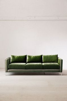 a green couch sitting on top of a white floor