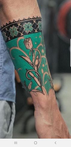 a man with a green and black tattoo on his arm