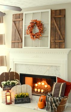 the fireplace is decorated with candles and wreaths