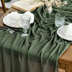 the table is set with green linens and silverware