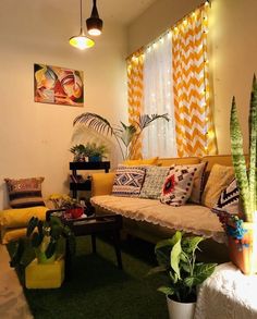 a living room filled with lots of furniture and plants on top of green carpeted flooring