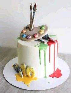 there is a cake that has been decorated with paintbrushes and paints on it