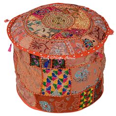 an orange round patchwork ottoman with tassels