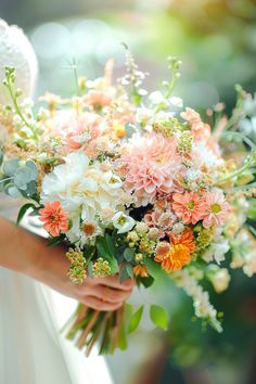 a bride holding a bouquet of flowers in her hands