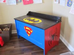 a child's dresser with superman symbol painted on the top, and spiderman decals on the bottom