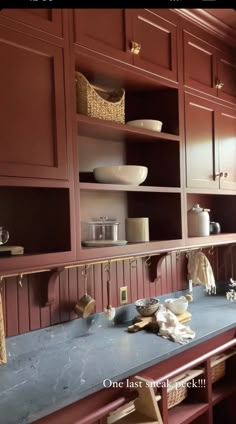 a kitchen with wooden cabinets and blue counter tops in front of a large window that reads, one last at check