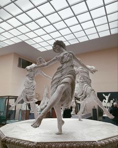 a statue of a man and two dogs in a room with glass ceiling tiles on the walls