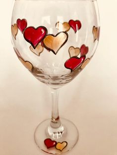 a wine glass with hearts painted on it