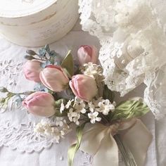 a bouquet of flowers sitting on top of a table next to a lace doily